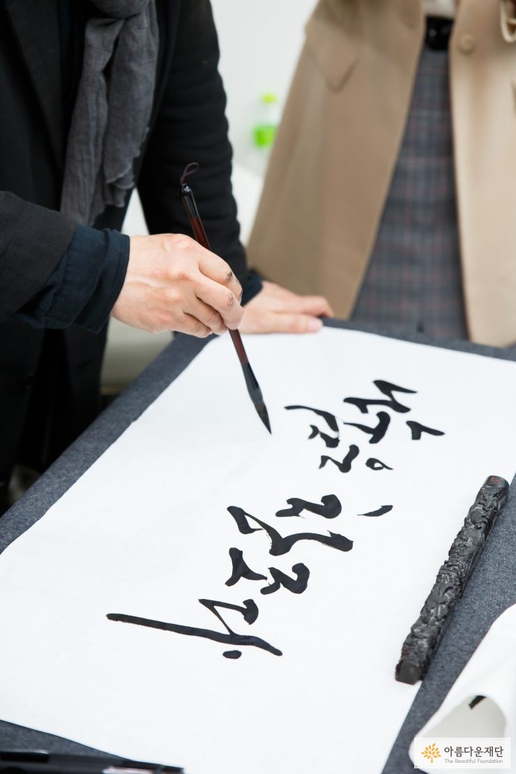 캘리그라피를 쓰고 있는 강병인 작가의 손