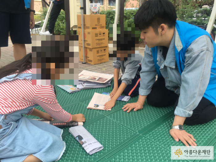 동네 어린이들에게 스마트폰 없이도 할 수 있는 재미난 놀이를 알려주는 모습