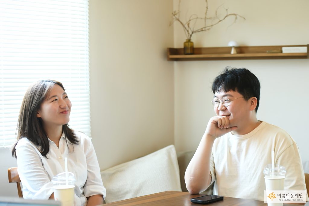 왼쪽에 주지은활동가, 오른쪽에 최민욱 활동가가 앉아있다. 두명 모두 하얀색 옷을 입고 있다.