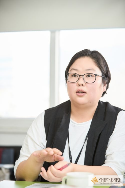 안경을 낀 젊은 여성이 인터뷰하고 있다