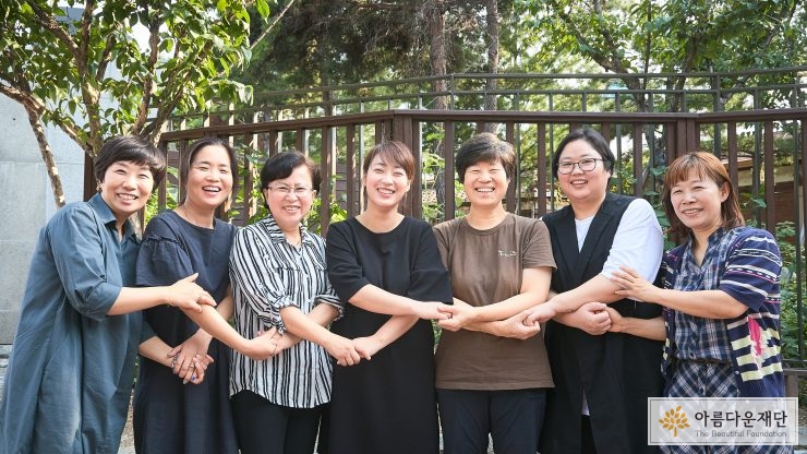 중랑지역 활동가인 일곱명의 여성이 손을 맞잡고 웃고 있다