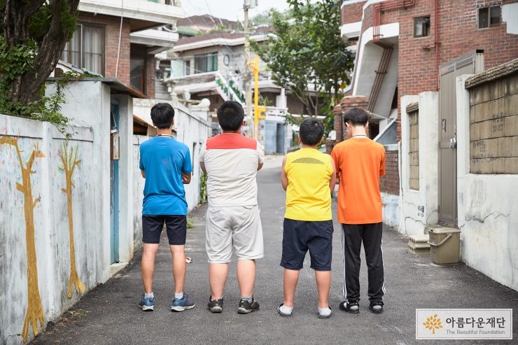 4명의 친구들이 뒷모습을 보여주며 서있다 